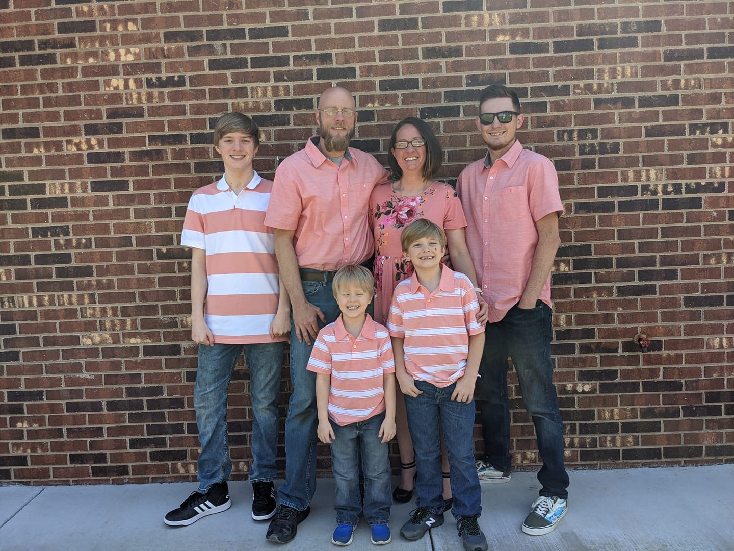 Classic family photo of happy family of 6 matching in pink