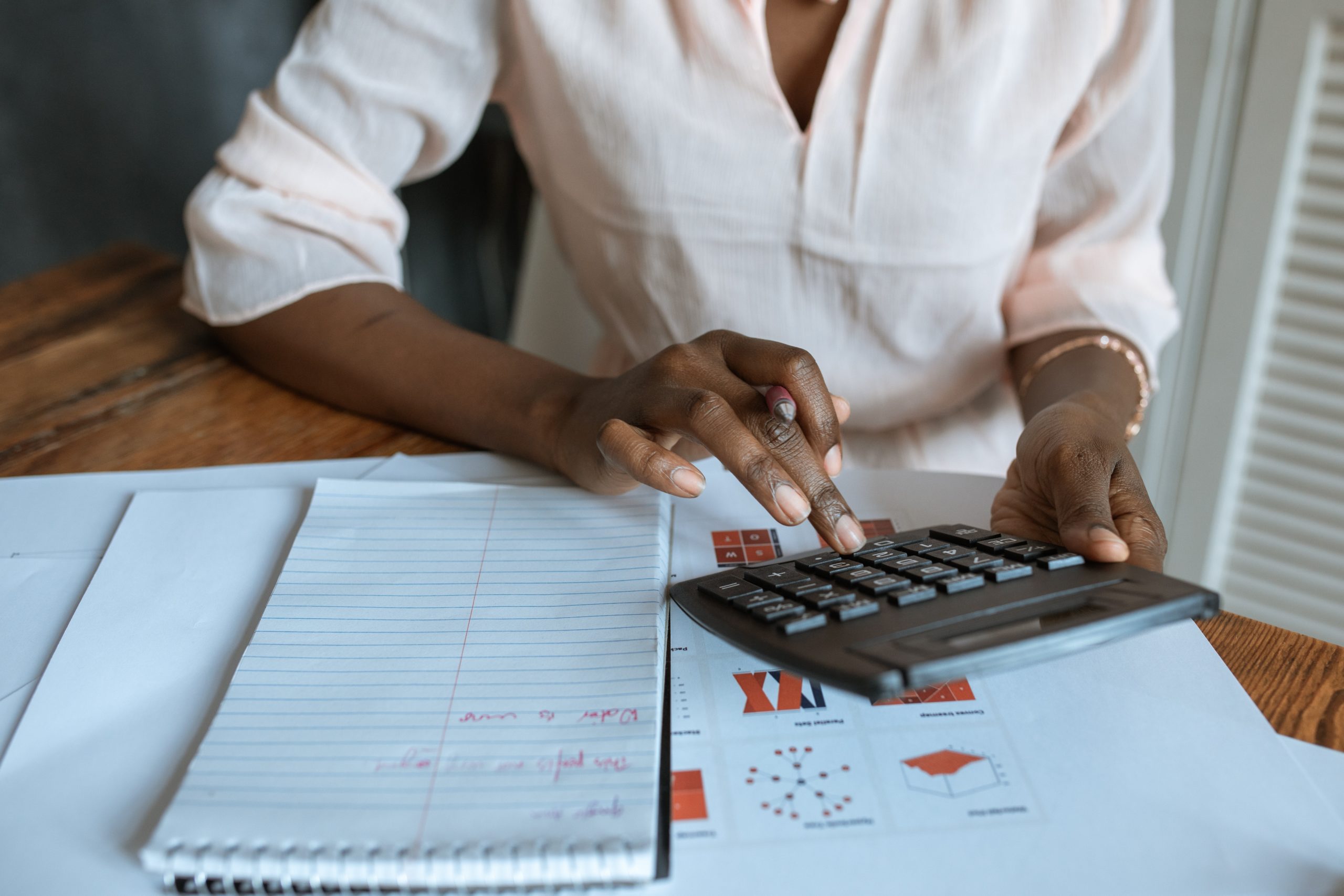 Woman using a calculator to figure numbers on documents